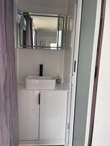 a bathroom with a sink and a mirror at Black Canyon Campground Modern Sleeping Pods Tiny Homes in Black Canyon City