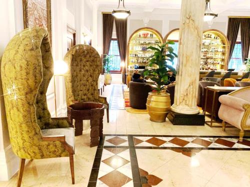 a lobby with chairs and a table and a restaurant at Taj 2 bed Suite - deluxe with lounge, kitchen & stunning Table Mtn views near top floor in Cape Town