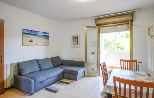 ein Wohnzimmer mit einem blauen Sofa und einem Tisch in der Unterkunft 1 Bedroom Lovely Apartment In Andora in Marina dʼAndora