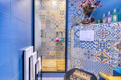 a bathroom with blue and white tiles on the wall at PARIS-JulesVERNE-Bienvenue-Terrasse-Netflix in Pantin