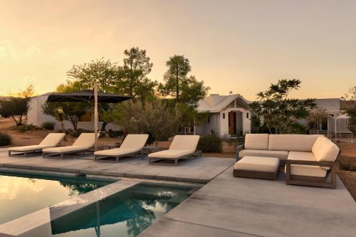 een zwembad met ligstoelen en een parasol naast een zwembad bij La Grange by The CoHost Company in Rimrock