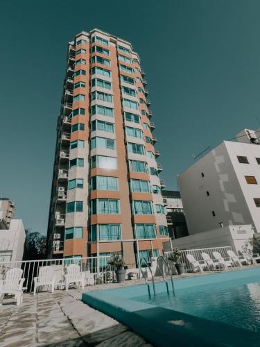 a tall building with chairs and a swimming pool at Millennium between 5th floor in Mendoza