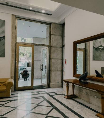 a living room with a table and a mirror at Millennium Mendoza pleno Centro 2 dormitorios, cocina completa, pileta y terraza in Mendoza