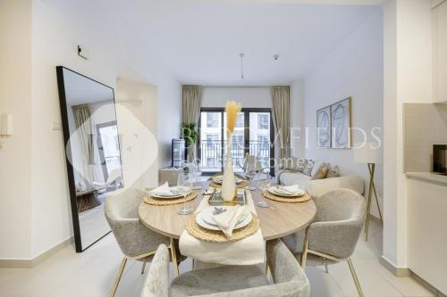 a dining room with a table and chairs and a couch at Bloomfields Cozy 1br Apt Town Square in Dubai