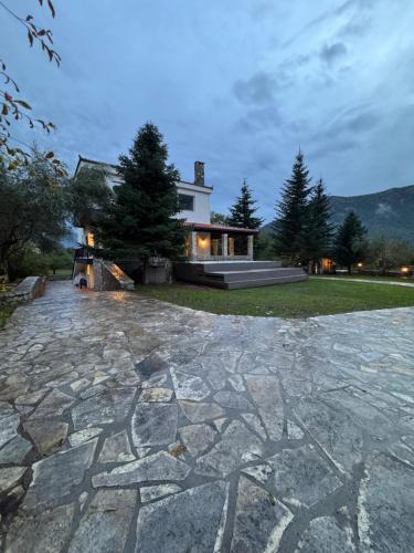 un gran patio de piedra frente a una casa en eleni's villa, en Kandhíla