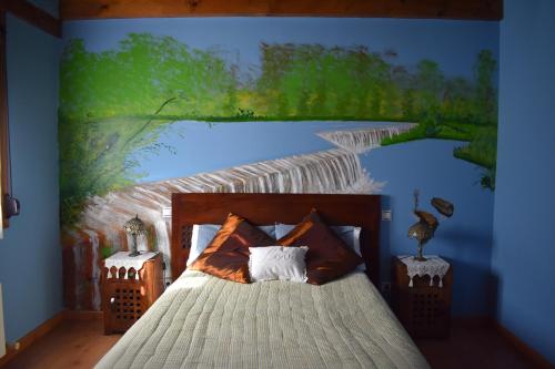 Un dormitorio con un cuadro de un río. en Hotel Rural Colas, en Montejo de Cevas