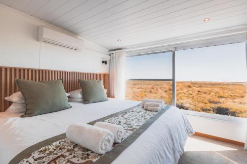 a bedroom with a large bed with a large window at Chobe Princess by Mantis in Kasika