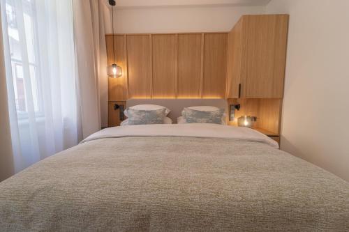 a bedroom with a large bed with two pillows at Six Residences Prague in Prague