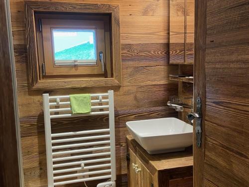 a bathroom with a sink and a window at Chalet Les Ravaires, Morgins in Troistorrents