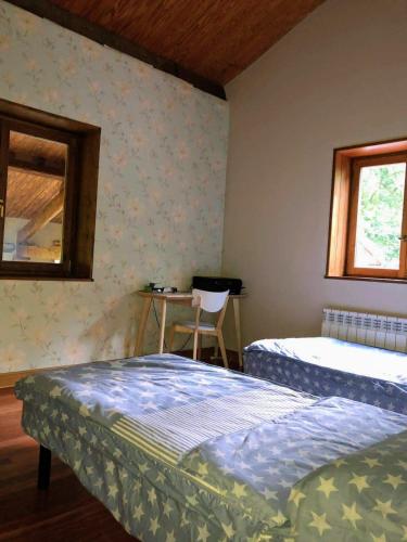 a bedroom with two beds and a table and a chair at Villa Elorrio in Elorrio
