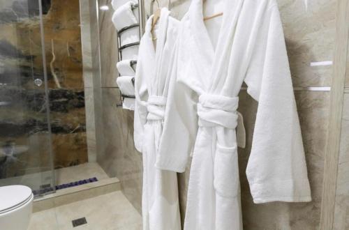 タシュケントにあるArt Dream Hotelの浴室に掛けられた白いタオルの束