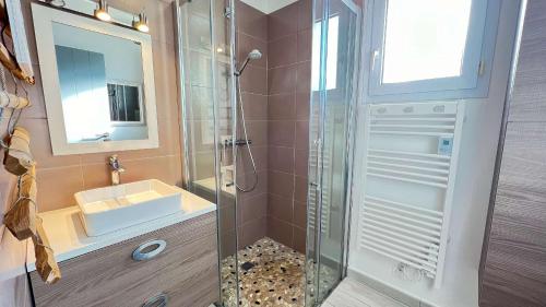 a bathroom with a shower and a sink and a mirror at Jolie maison avec jardin à proximité de la plage in Saint-Clément-des-Baleines