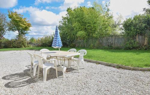 a table and chairs with an umbrella on top of it at Maison De Charme Proche Mer in Saint-Germain-de-Tournebut