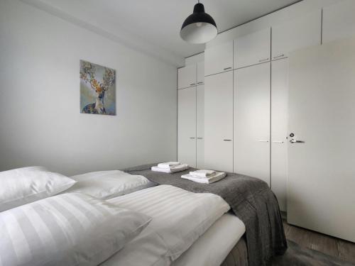 a white bedroom with two beds and a closet at Convenient Apartment for 2 with Sauna in Kemi