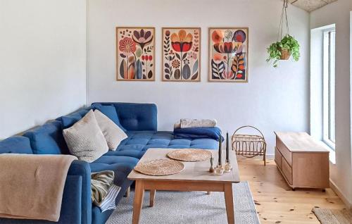 a living room with a blue couch and a table at Beautiful Home In Ærøskøbing in Bro
