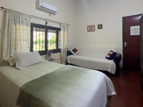 a bedroom with two beds and a window at Casa de Verano en Ypacarai con lago natural, Piscina, Naturaleza y Comodidad para Grupos in Ypacarai