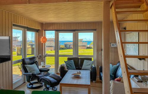 Una sala de estar con una escalera y una mesa y sillas. en Amazing Apartment In Faaborg With Sauna, en Nabbe