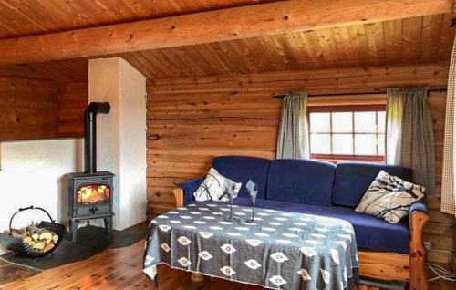 a living room with a blue couch and a stove at Stunning Home In Oppdal With Sauna in Fagerhaug