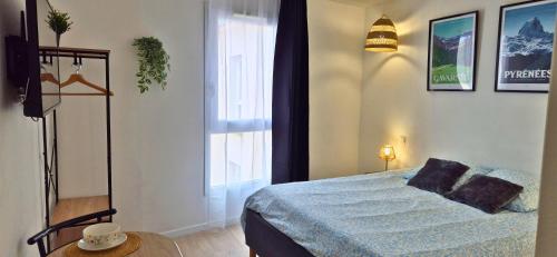 ein Schlafzimmer mit einem Bett und einem großen Fenster in der Unterkunft L'Escale - Double matelas - Clim - Wifi in Lourdes