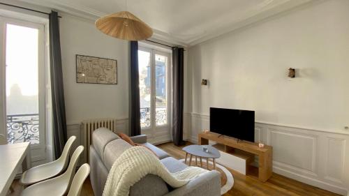 a living room with a couch and a tv at POITTE - Appartement Rennes 10P in Rennes