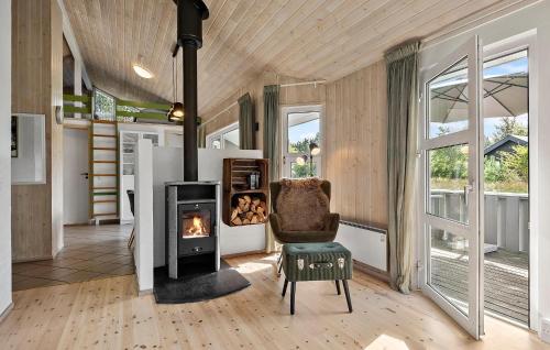 a living room with a fireplace and a chair at Lovely Home In Nørre Nebel With Sauna in Lønne Hede