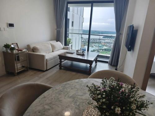 a living room with a table and a couch at 2BR Cozy Apartment- River and Park View- Masteri Centre Point - HCM in Ho Chi Minh City