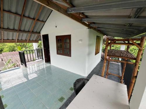 an outside view of a house with a table and chairs at Silver Cliff Bungalow in Than Sadet Beach