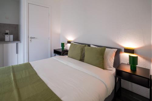 een slaapkamer met een groot wit bed met twee lampen bij La Chasse 5 in Brussel