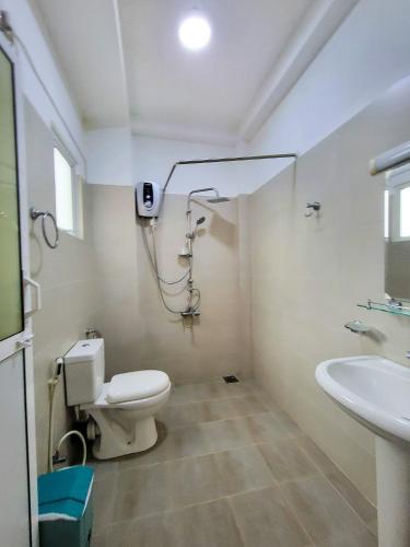 a bathroom with a toilet and a sink at Nuwan Inn in Hikkaduwa