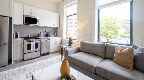 a living room with a couch and a kitchen at Landing Apartments - Birmingham in Birmingham