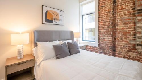a bedroom with a bed and a brick wall at Landing Midtown in Birmingham