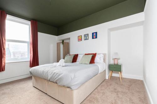 une chambre avec un grand lit et une fenêtre dans l'établissement Spacious 3BR • WiFi • Parking • Contractor Stay, à Monkwearmouth