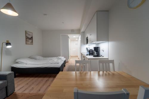 ロヴァニエミにあるSnowflake IXのベッド、テーブル、キッチンが備わる客室です。