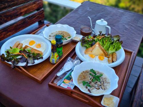 a table with two trays of food on it at Viman keeree doichang วิมานคีรี ดอยช้าง in Ban Huai Khai