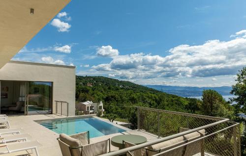 Cette maison dispose d'une piscine et d'un balcon avec des chaises. dans l'établissement Stunning Home In Poljane With Sauna, à Poljane