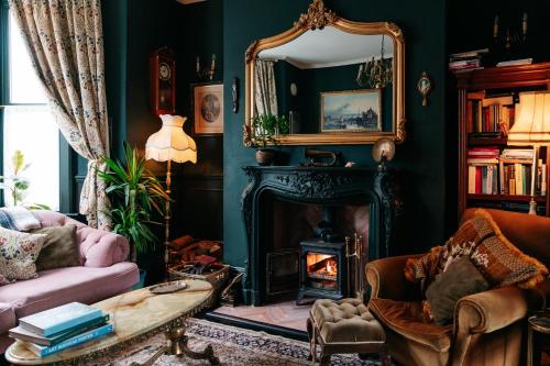 a living room with a fireplace and a mirror at Bohemian Retreat by the Sea with wood burner, roll-top bath & leafy garden in Margate