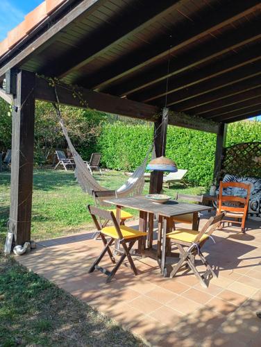 a patio with a table and chairs and a hammock at Relax y Bienestar in Izarra