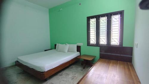 a small bedroom with a bed and a window at Aruna homes Thanjavur in Thanjāvūr