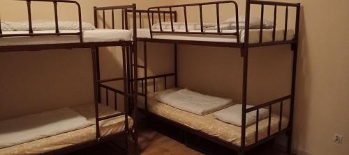 a room with three bunk beds in a room at Rembrandt Hostel in Kraków
