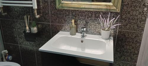 a bathroom with a white sink and a mirror at Rembrandt Hostel in Kraków