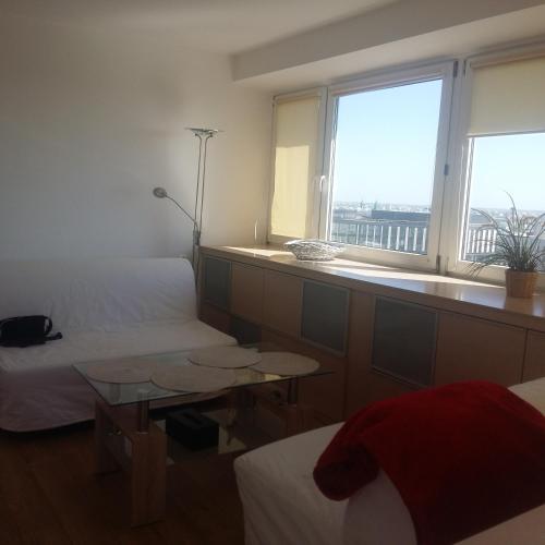 a room with two beds and a table and a window at Alma Apartments in Warsaw