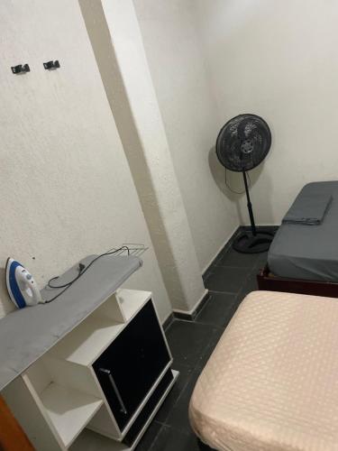a room with a desk and a bed and a fan at Albuquerque nro36 casa 3 in Campinas