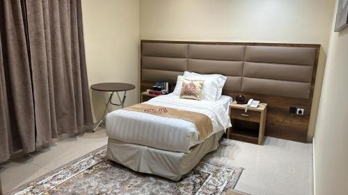 a bedroom with a large bed and a table at AL Tamayoz Alraqi - Alsulaymaniyah branch in Jeddah