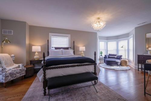 a bedroom with a bed and a chair and a couch at Riggs House Restored 1908 Home in Maquoketa