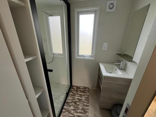 a bathroom with a shower and a sink and a mirror at 531 Mobi-Chalet 3 chambres 2 sd Bassin d'Arcachon in La Teste-de-Buch