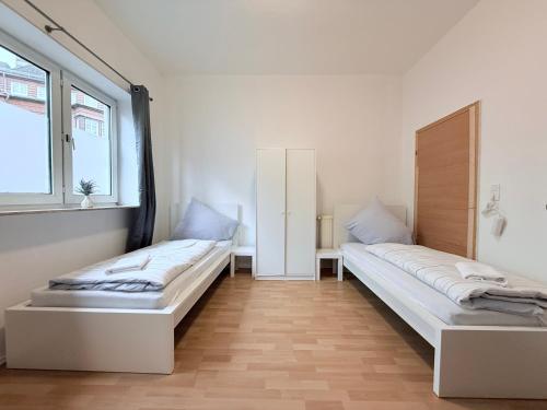 due letti in una stanza con due finestre di Apartments Neumünster für Firmen & Monteure a Neumünster