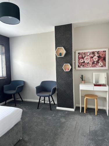 a room with two chairs and a desk and a bed at Luxurious Room in Hackington