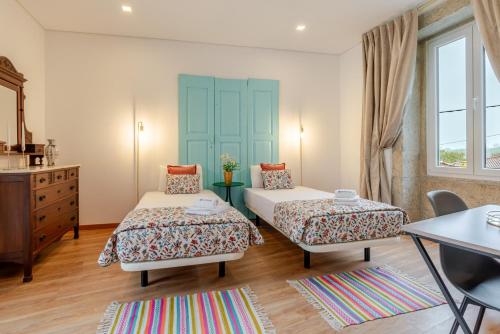 a bedroom with two beds and a dresser at Rustic & Modern Stone House by Host Wise in Pedroso