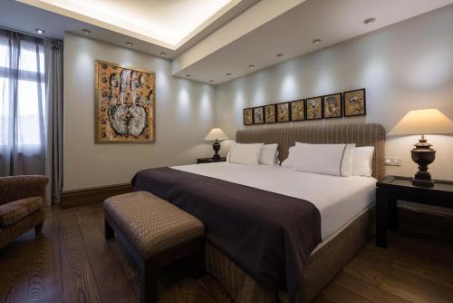 a hotel room with a large bed and a chair at Eurostars Al-Ándalus Palace in Seville