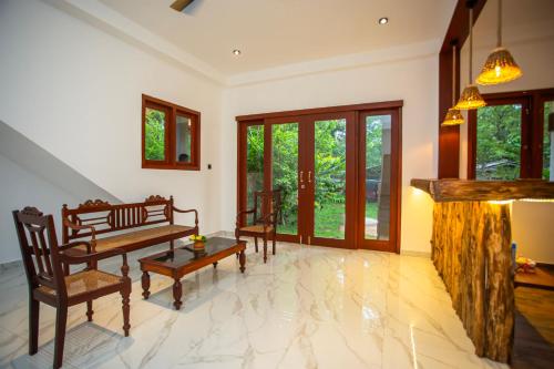 a living room with a bench and a fireplace at Villa Claudia Nimal's kitchen in Ahangama